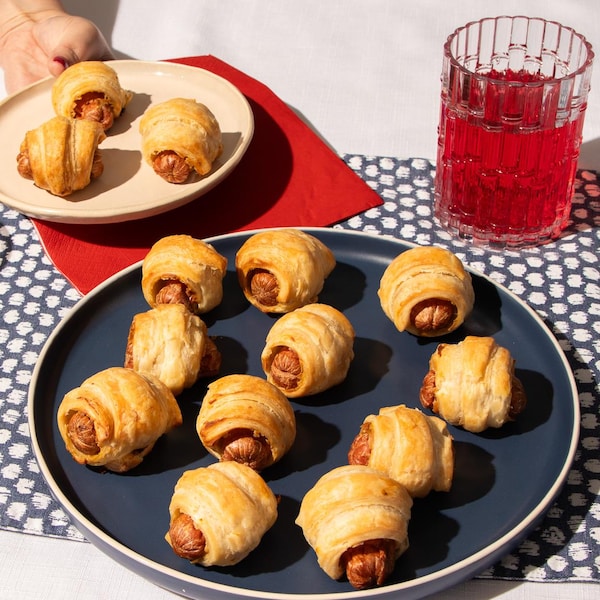 Des saucisses enroulées de pâte feuilletée dans une assiette.