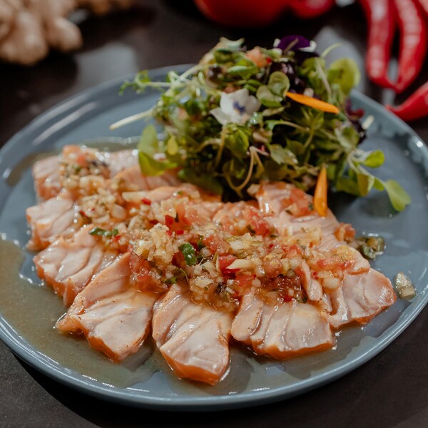 Des tranches de saumon dans une assiette avec de la salade.
