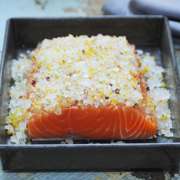 Un filet de saumon recouvert de sel pour en faire un gravlax.