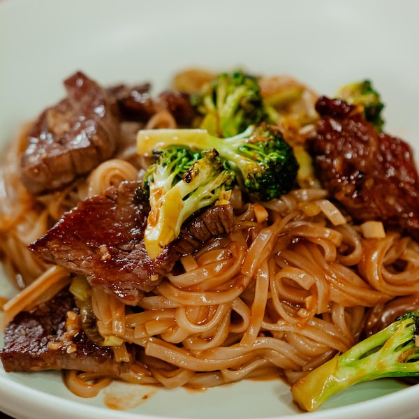 Un bol de sauté de bœuf au brocoli servi sur des nouilles de riz.