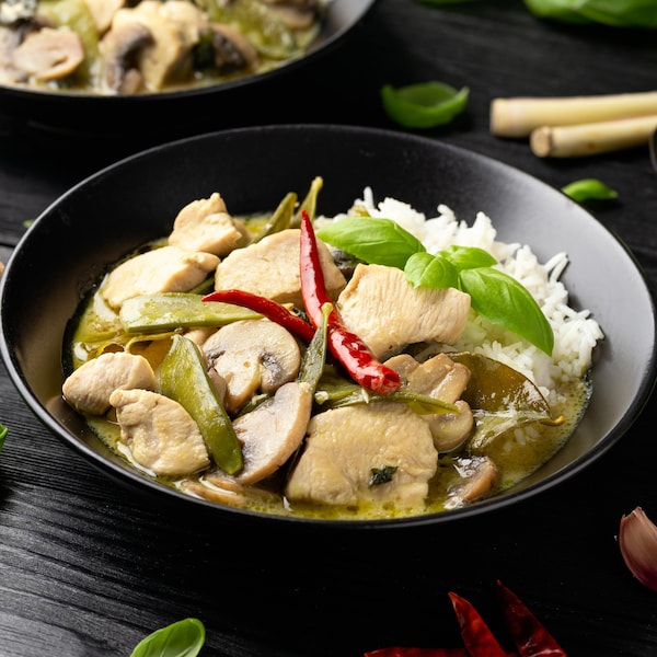 Un bol de sauté de poulet et de légumes au lait de coco et au cari vert.