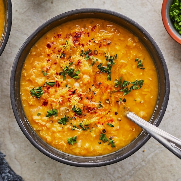 Deux bols de soupe citronnée aux lentilles sur une table.