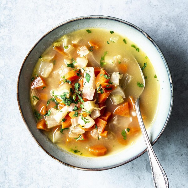Un bol de soupe aux légumes avec une cuillère.