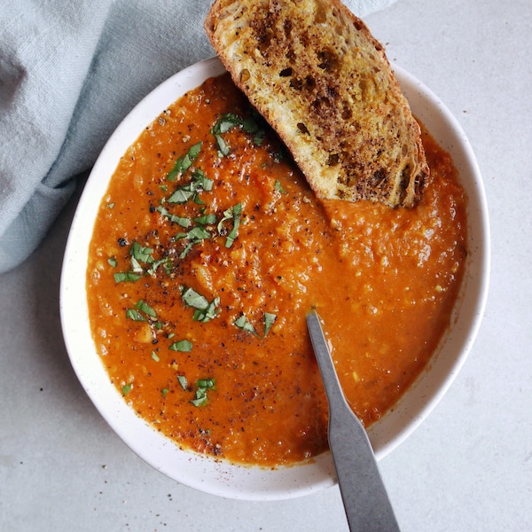 Vue en plongée d'un bol de soupe de lentilles avec un croûton et une cuillère dans le bol.