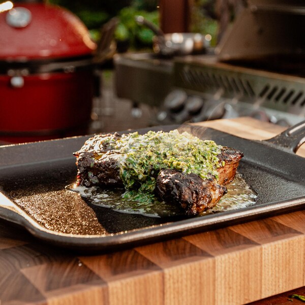 Un steak grillé au BBQ servi avec du beurre aux herbes.