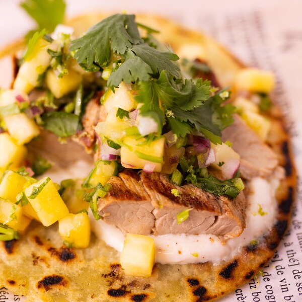 Zoom sur un tacos au filet de porc au chili et à la coriandre.