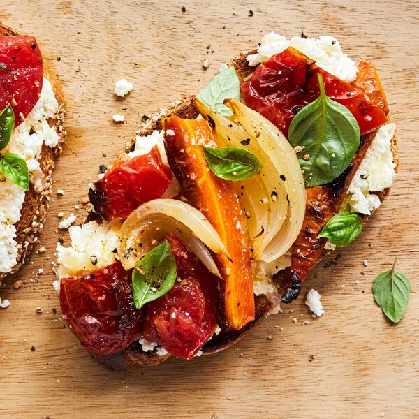 Tartines aux fromages et aux tomates rôties sur une table.