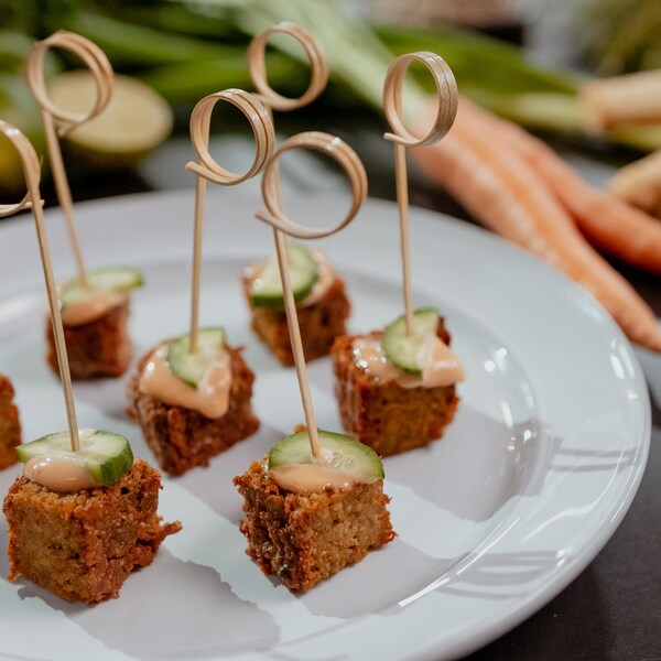 Des cubes de végépâté garni de sauce et de concombres.