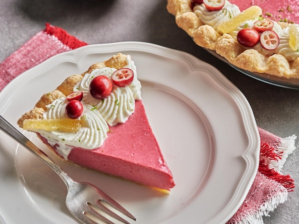 Une tarte aux canneberges et une part déjà coupée dans une assiette.