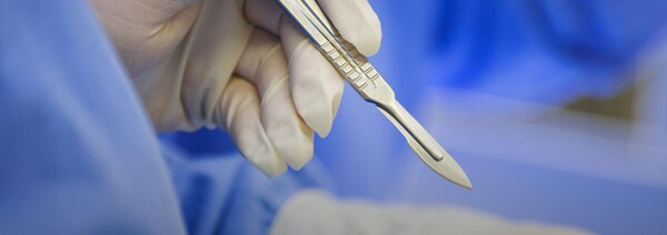 Un chirurgien manipule un scalpel.