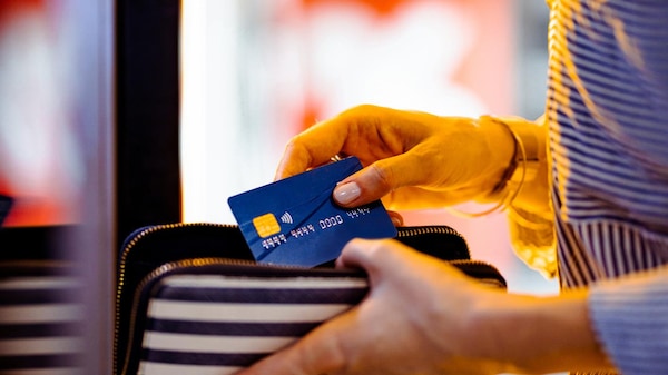 Une femme utilise un guichet ATM avec sa carte de crédit.