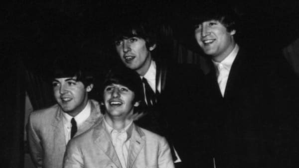 Les Beatles posent pour les journalistes près de la batterie de Ringo Starr.