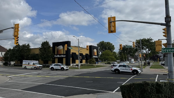 Deux autopatrouilles et une ambulance stationnées dans un périmètre de sécurité devant The Beer Store.