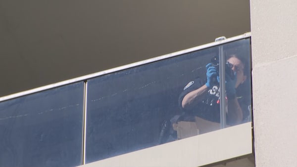 Une policière prends des photos du balcon en question.