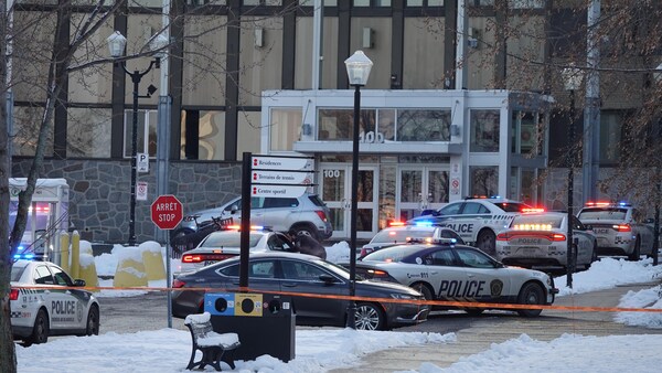 Des voitures de police stationnées devant l'entrée du collège.