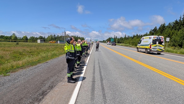 Des travailleurs paramédicaux saluent le cortège.