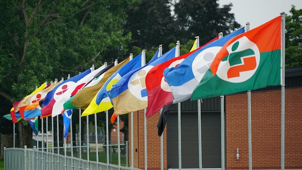 Des drapeaux des Jeux du Québec enlignés.
