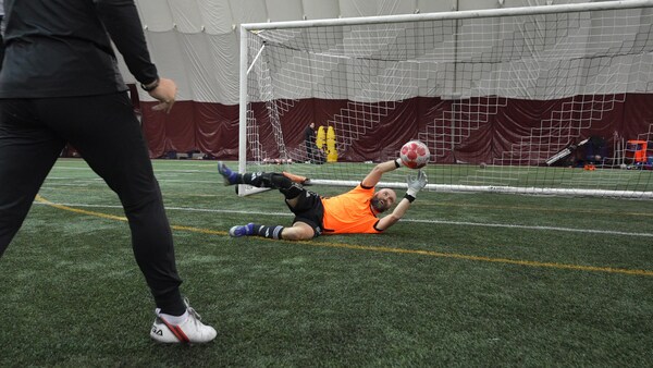 Jonathan Jobin s'élance devant un but de soccer pour bloquer un ballon.
