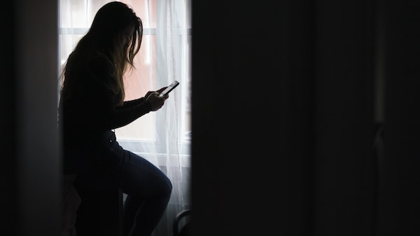 Une femme consulte son téléphone cellulaire avec attention.