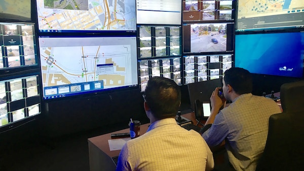 Deux employés scrutent les écrans du centre de gestion de la mobilité intelligente.
