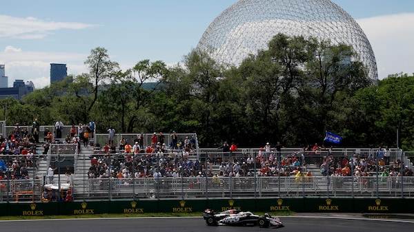 Une voiture F1 sur le circuit Gilles-Villeneuve avec la biosphère en arrière-plan.