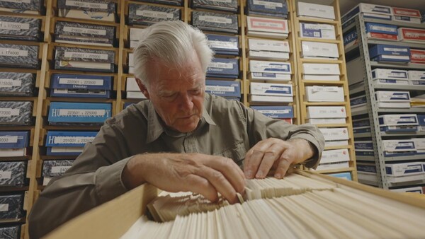 Jacques Larivée consulte une boite de feuillets de recensement d'oiseaux.