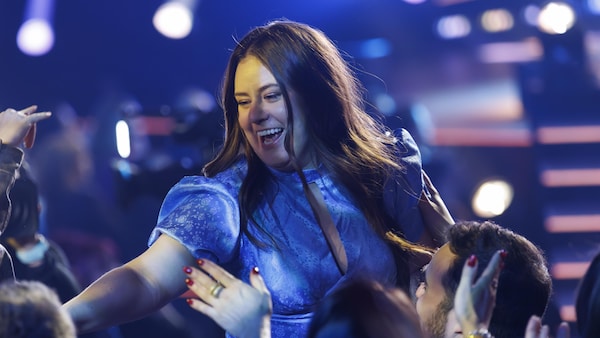 Mégan Brouillard se réjouit, debout parmi des personnes assises.