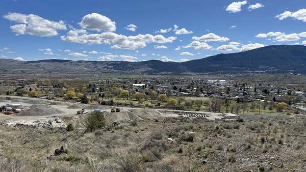 Image de Merritt prise d'une colline au nord de la ville l'où on voit le terrain de golf, la ville et les collines au fond.