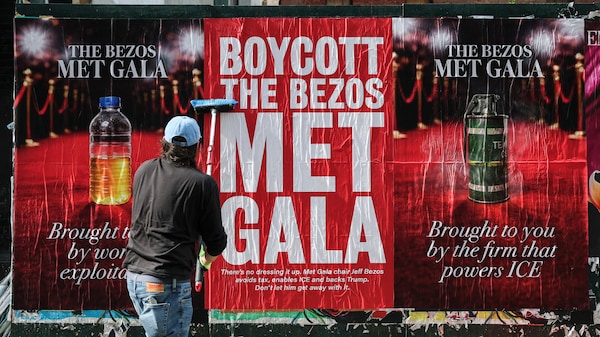 Une personne appose des affiches « Boycottons le Met Gala de Bezos » à New York, le 15 avril 2026. 