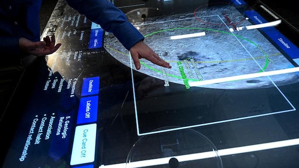 Un employé utilise un écran tactile dans la salle des opérations des missions scientifiques du Centre spatial Johnson à Houston, au Texas, le 6 avril 2026. 