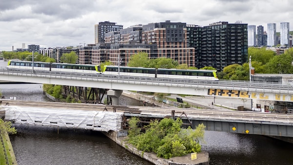 Un train du Réseau express métropolitain qui roule vers la ville de Montréal.