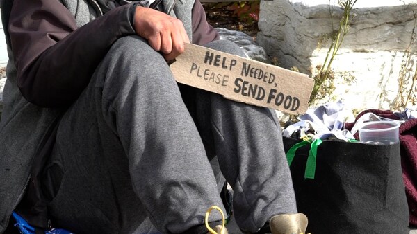 Una persona sin techo pide ayuda para alimentarse.