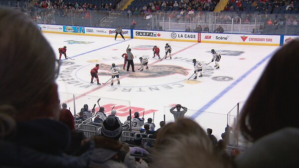 De jeunes joueurs de hockey se préparent à la mise au jeu. 