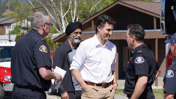 Le premier ministre Justin Trudeau avec des pompiers à Kelowna, le 10 mai 2024.