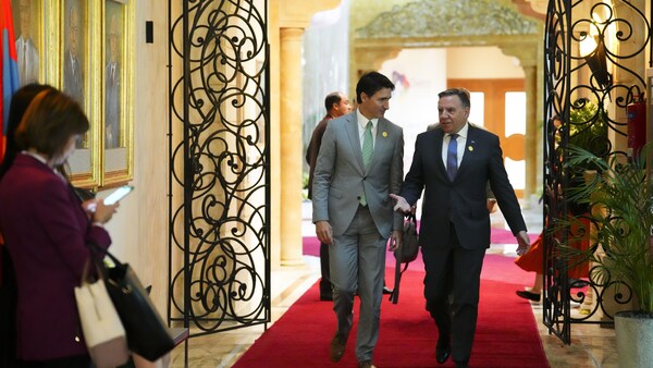 Justin Trudeau et François Legault en train de marcher dans un corridor en discutant. 