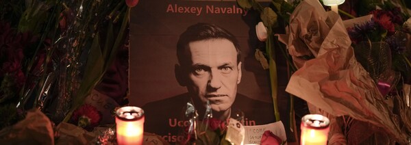 Des fleurs et des bougies entourent une photo d'Alexeï Navalny.