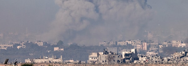 De la fumée au-dessus d'une ville après un bombardement.
