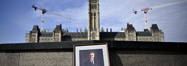 Un portrait encadré de l'ancien premier ministre Brian Mulroney est adossé à la Flamme du centenaire sur la Colline du Parlement, à Ottawa. 