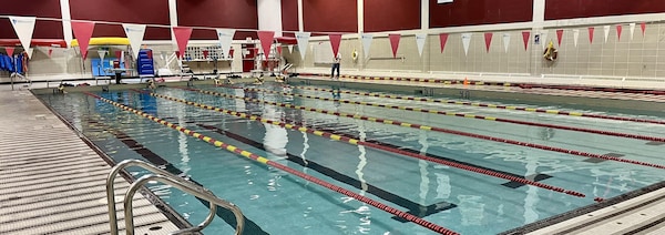 Des nageurs s'entraînent dans une piscine intérieure.