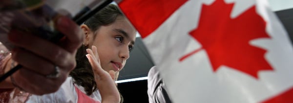 Des personnes prêtent serment durant une cérémonie d'octroi de la citoyenneté canadienne