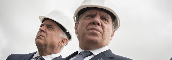 Le premier ministre du Québec François Legault et le ministre de l'Économie Pierre Fitzgibbon avec des casques de chantier.