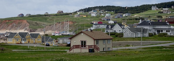 Des maisons dans un paysage du secteur de Millerand, sur l'île du Havre Aubert, aux Îles-de-la-Madeleine.  