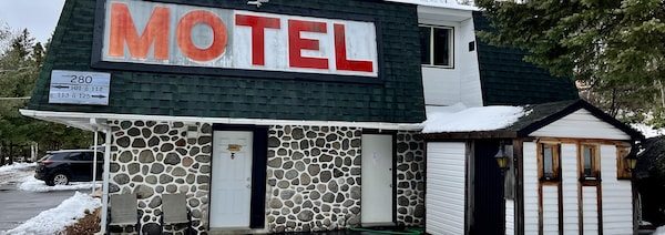 Une façade de motel un peu défraîchie avec une architecture qui rappelle les années 80.