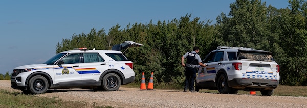 Des policiers de la Gendarmerie royale du Canada (GRC) forment un barrage routier près de la Nation crie James Smith, le 6 septembre 2022, dans le cadre de l'enquête sur la série d'attaques au couteau ayant eu lieu le 4 septembre 2022 en Saskatchewan.