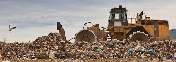 Un bulldozer pousse des déchets dans un site d'enfouissement.