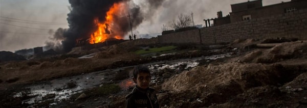 Un enfant irakien devant un puits de pétrole en feu à Al-Qayyarah, près de Mossoul.