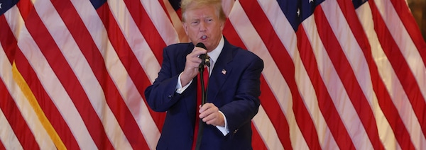 Donald Trump devant des drapeaux américains. 