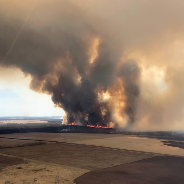 Un panache de fumée noire se dégage d'un grand feu de broussailles en Alberta, le dimanche 30 avril 2023.