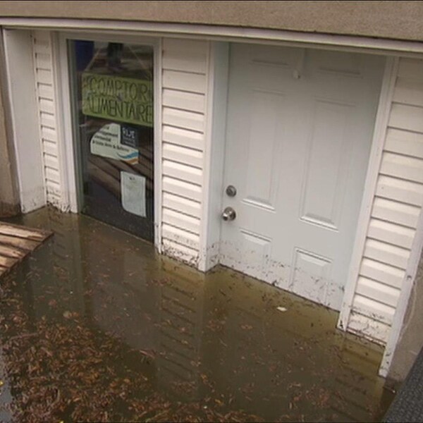 L'eau monte jusqu'à la moitié de la porte d'entrée du local du Comptoir alimentaire Sainte-Anne-de-Bellevue.
