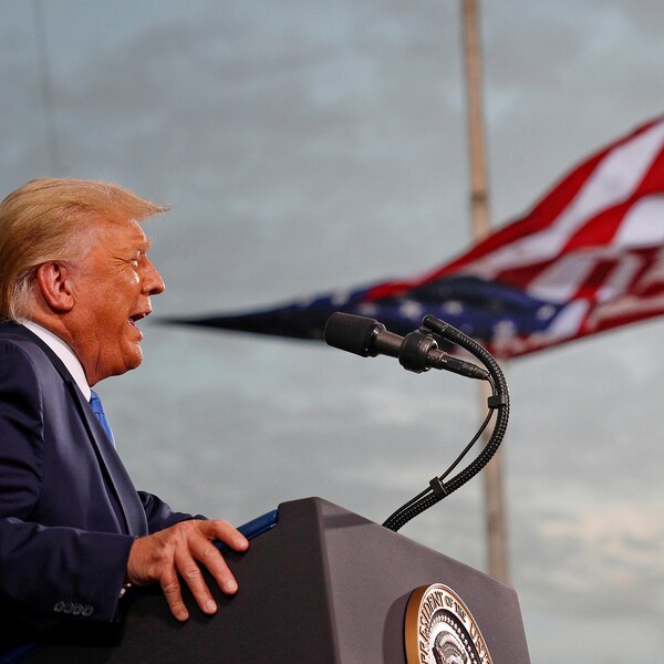 Donald Trump devant un drapeau américain.